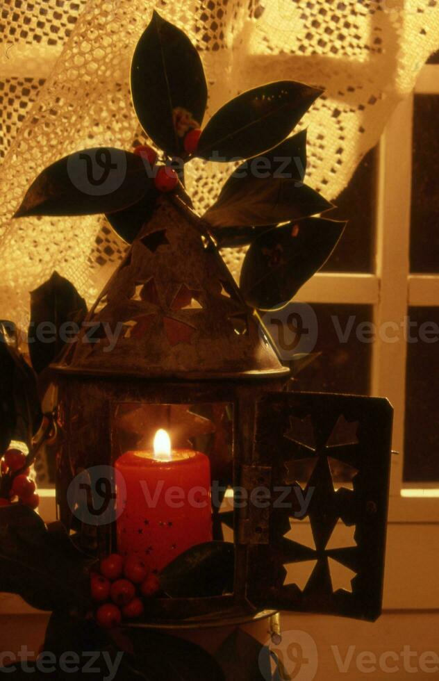 uma vela é aceso dentro uma pequeno lanterna com uma vermelho vela foto