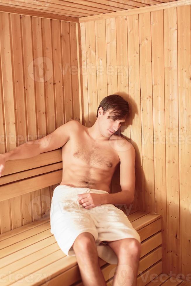 jovem relaxando na sauna foto