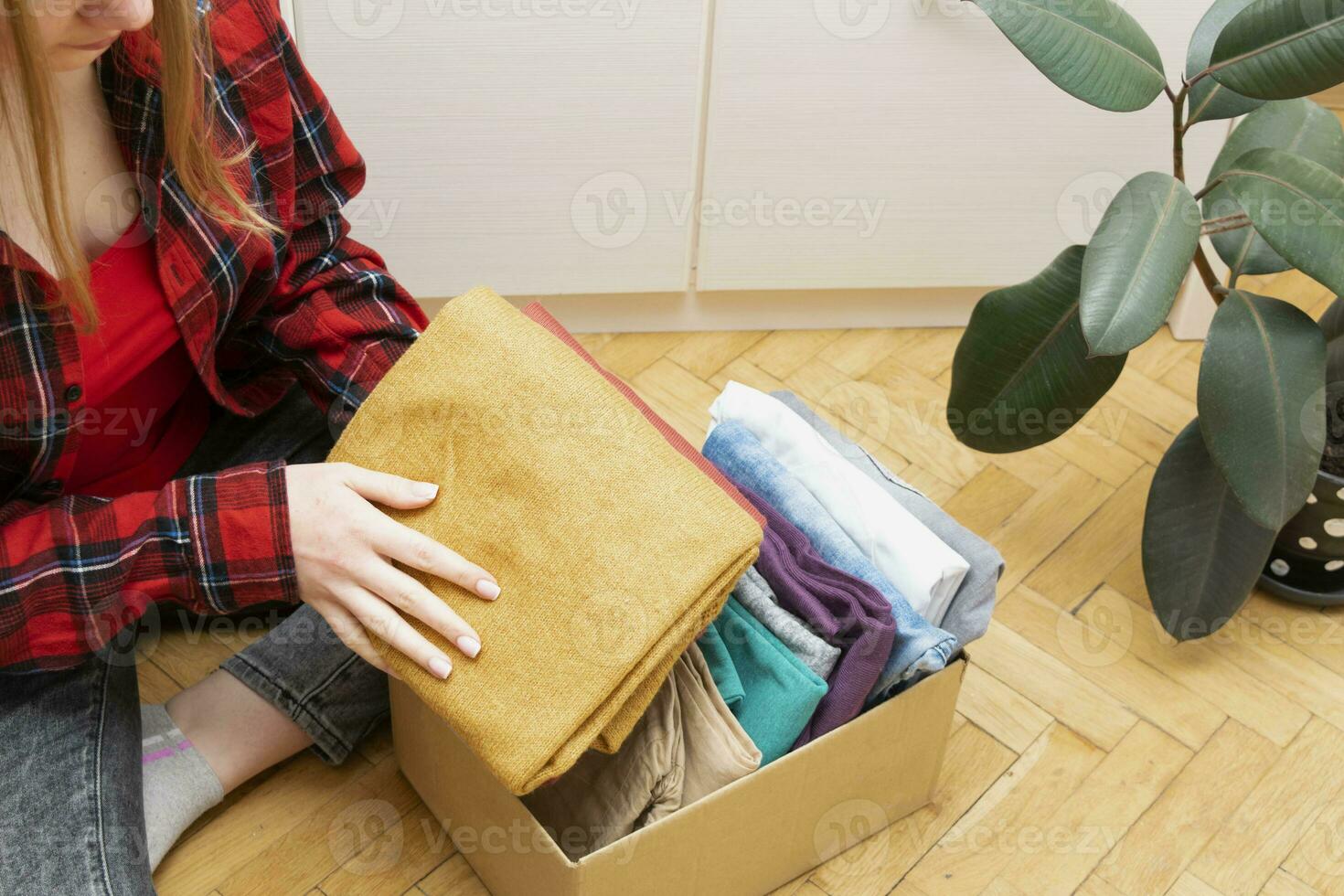 mulher pacotes roupas dentro caixas para doando. foto