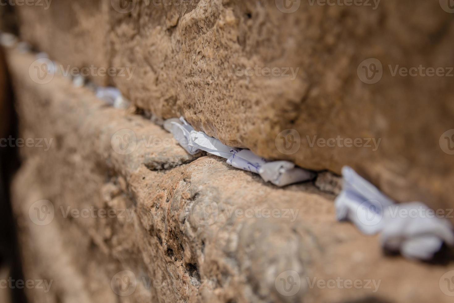 notas a Deus nas rachaduras entre os tijolos da parede ocidental da velha cidade de jerusalém israel foto