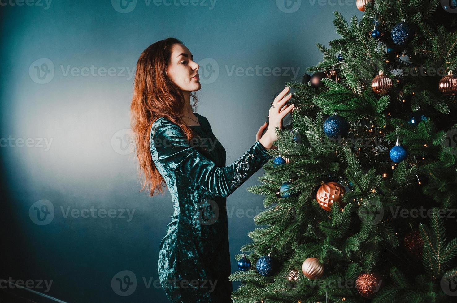 linda mulher morena decorando árvore de natal foto