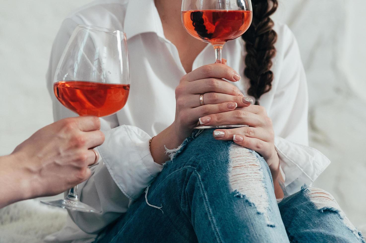 uma jovem segurando uma taça de vinho rosé foto