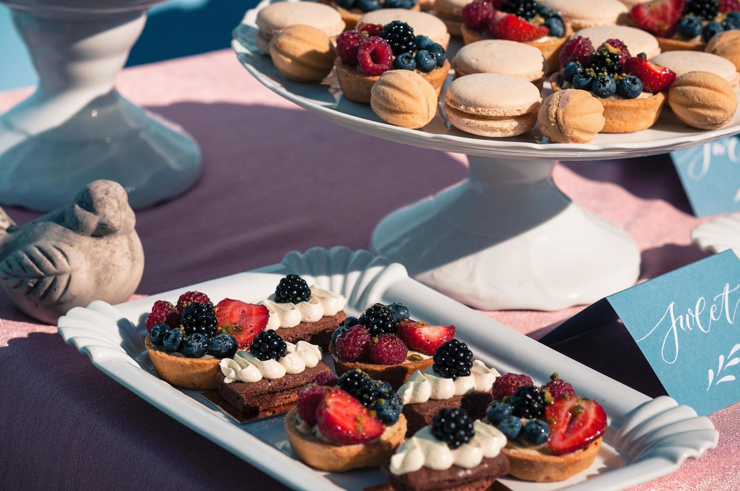 delicioso buffet de doces com cupcakes, macaroons e outras sobremesas foto