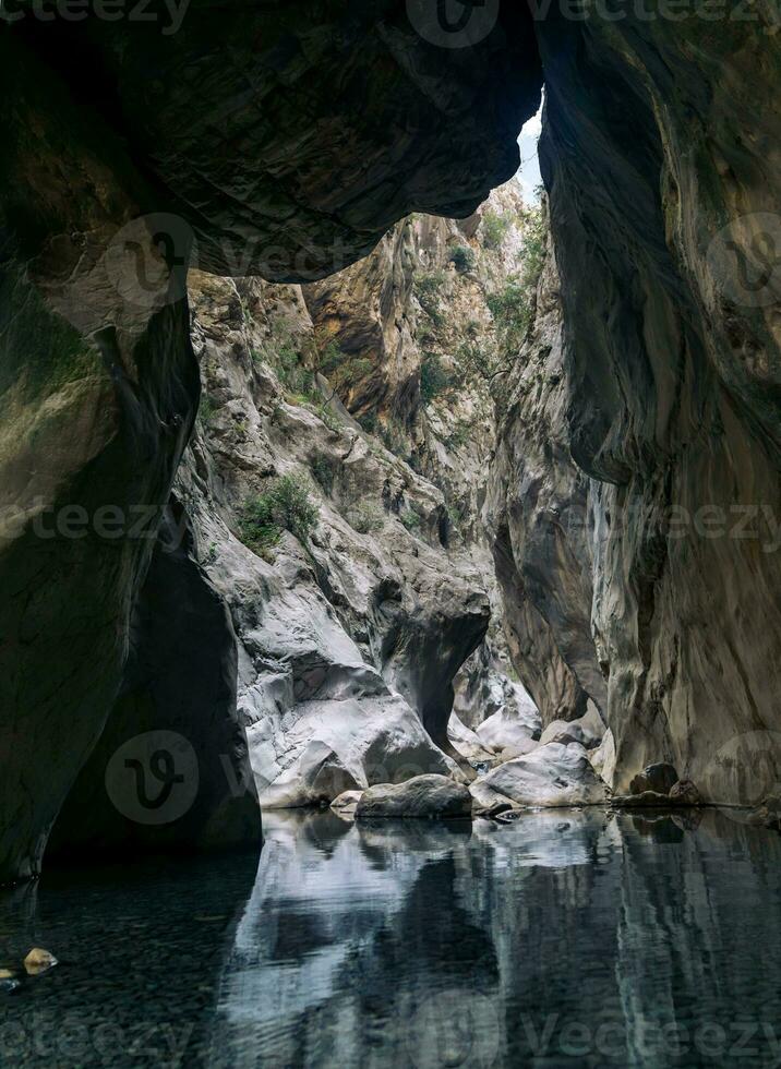 natural túnel dentro uma desfiladeiro com uma limpar \ limpo transparente rio foto