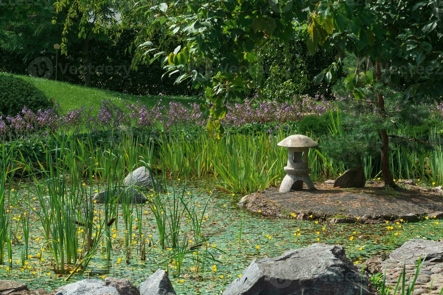 pedra lanterna em uma pequeno ilha dentro a meio do uma lagoa dentro uma japonês jardim foto