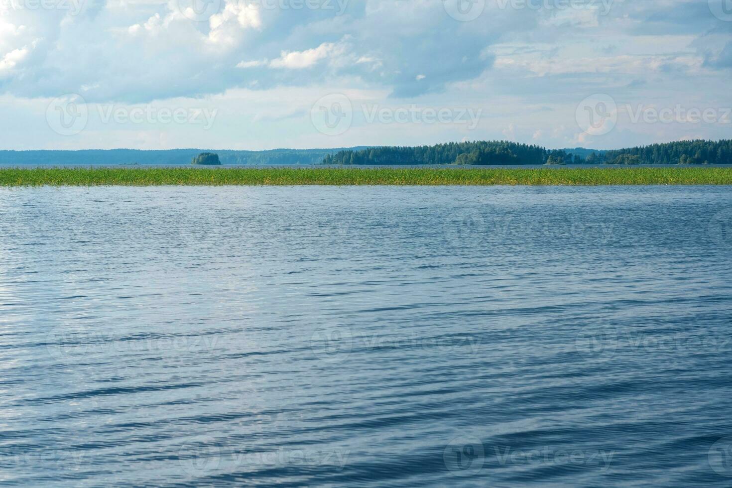 natural paisagem, Largo lago com cana bancos e distante litoral foto