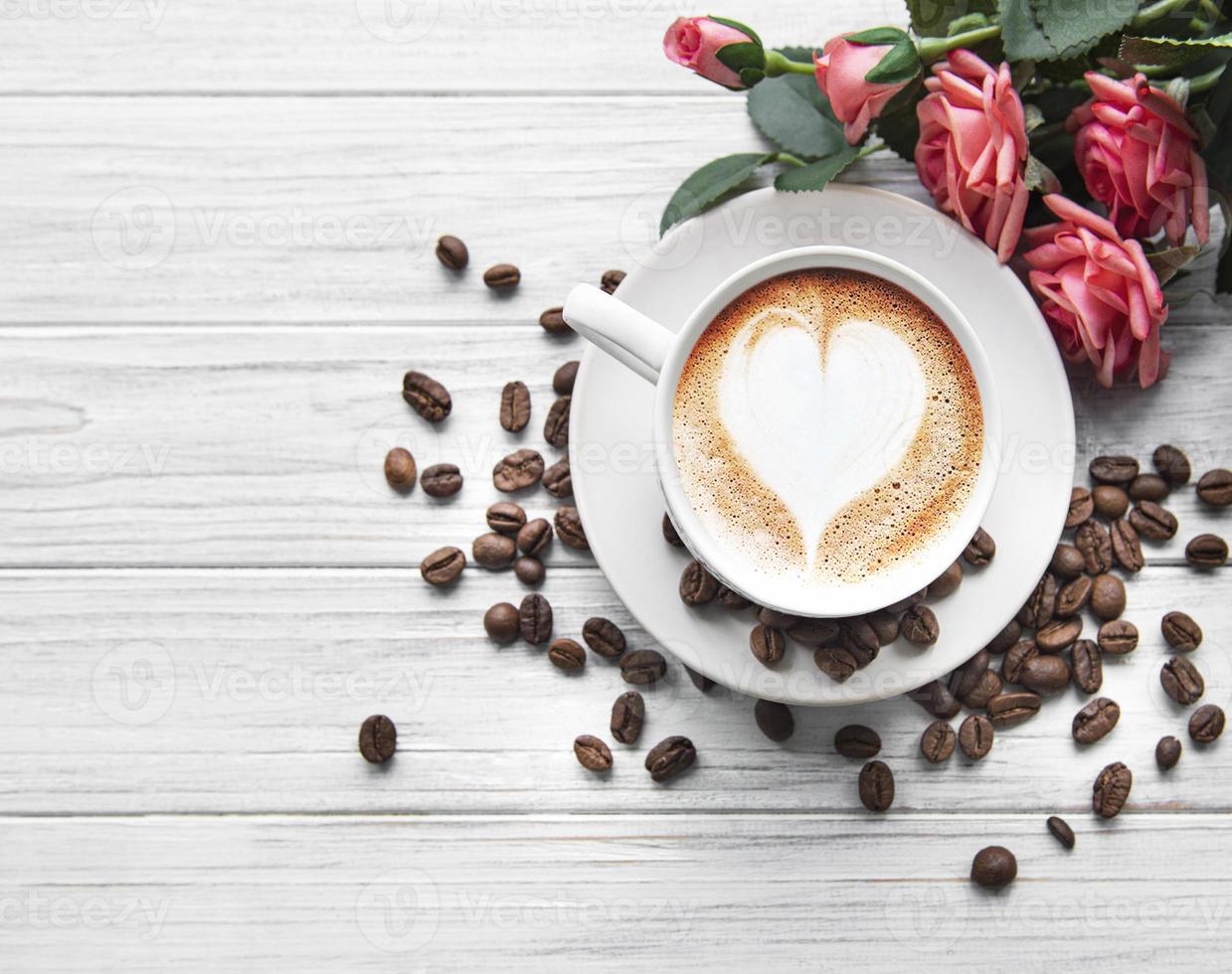 uma xícara de café com padrão de coração em uma mesa foto