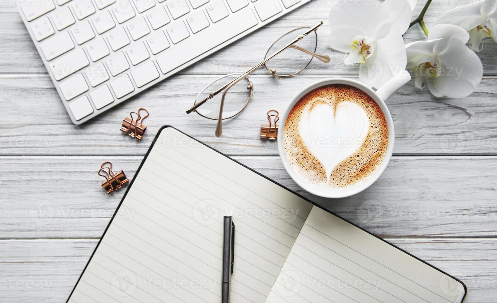 uma xícara de café com padrão de coração em uma mesa foto