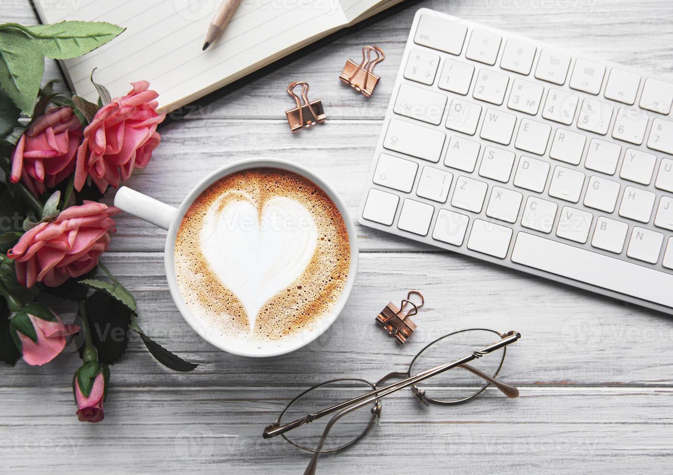 uma xícara de café com padrão de coração em uma mesa foto