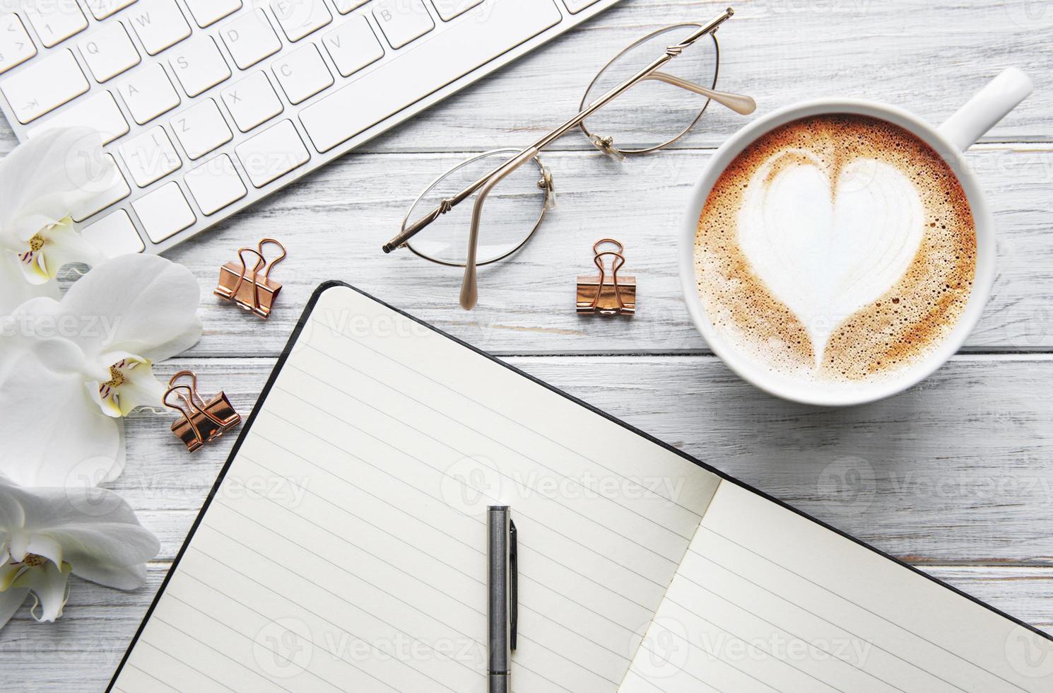 uma xícara de café com padrão de coração em uma mesa foto