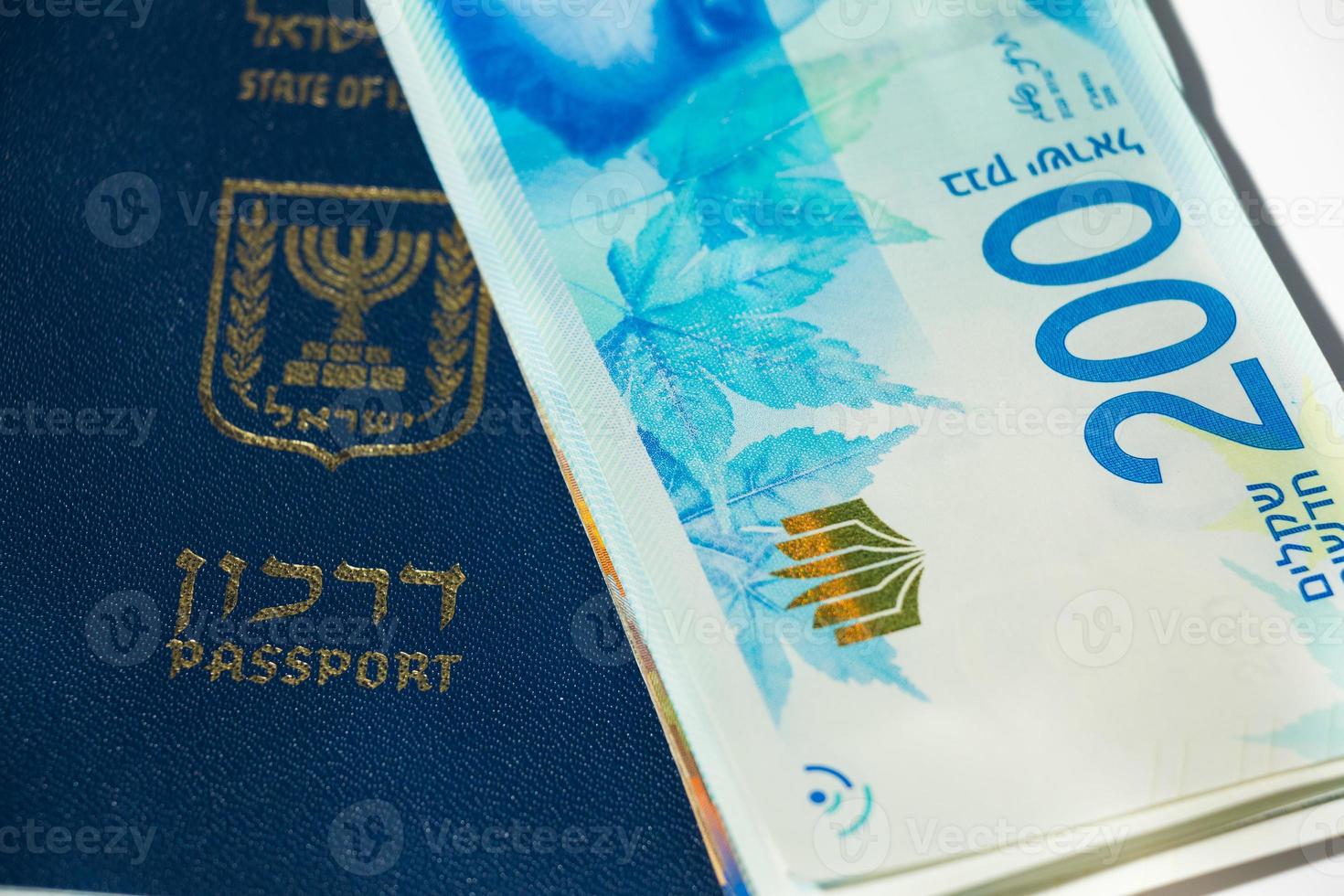 pilha de notas de dinheiro israelense de 200 shekel e passaporte israelense - vista superior foto