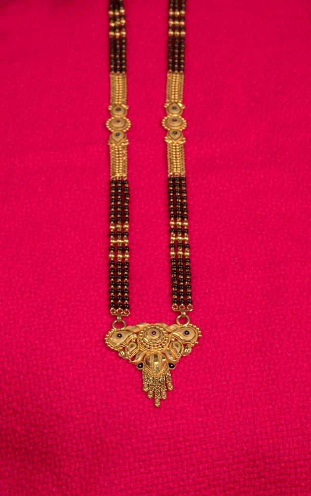 mangalsutra ou colar de ouro para usar por uma mulher hindu casada, arranjado com um lindo fundo. joalharia tradicional indiana. foto