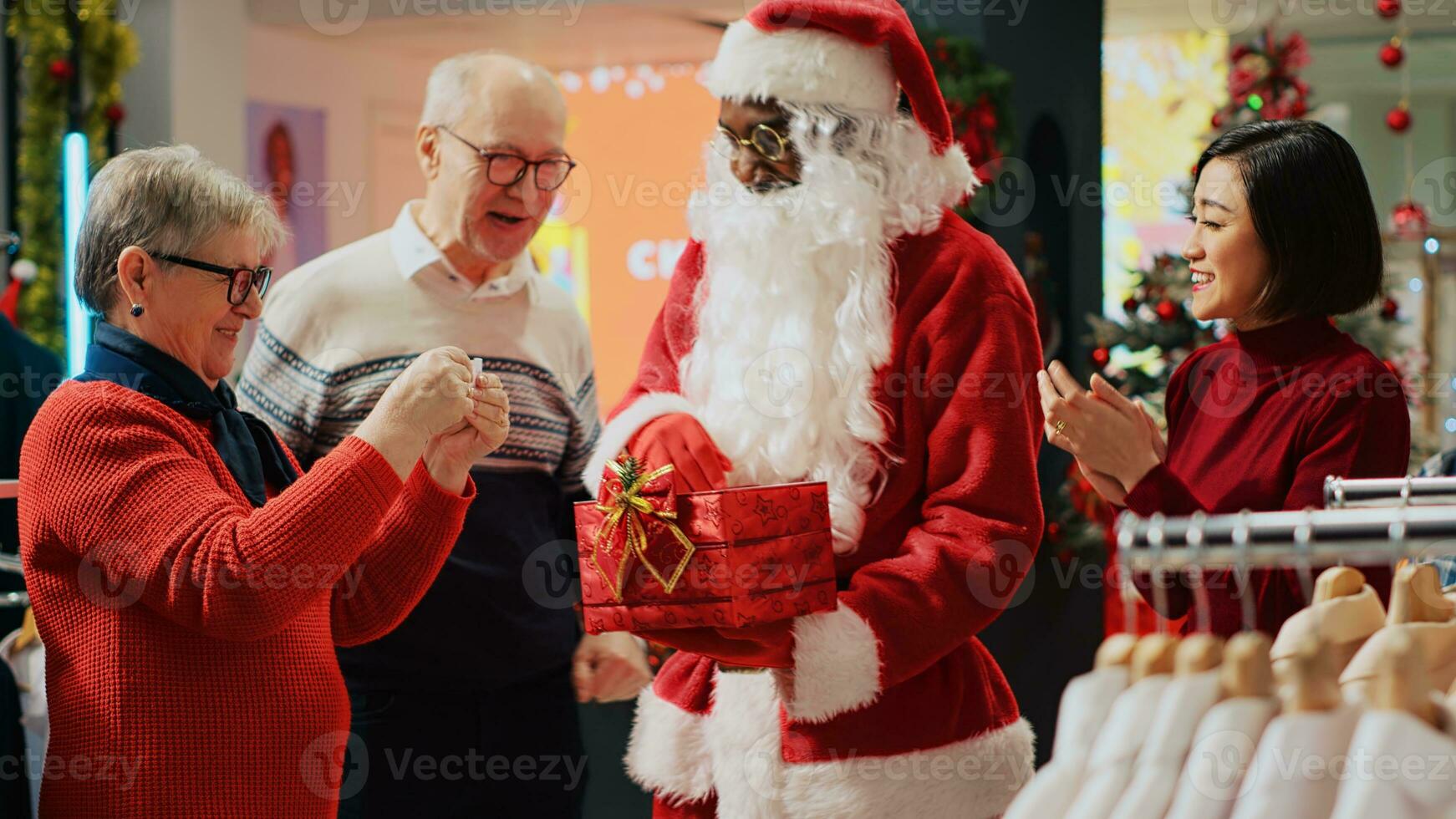 fechar acima tiro do homem vestido Como santa claus colheita sorteio bilhete dentro Natal decorado moda boutique durante festivo feriado temporada. por sorte Senior clientes ganhando roupas loja concurso foto