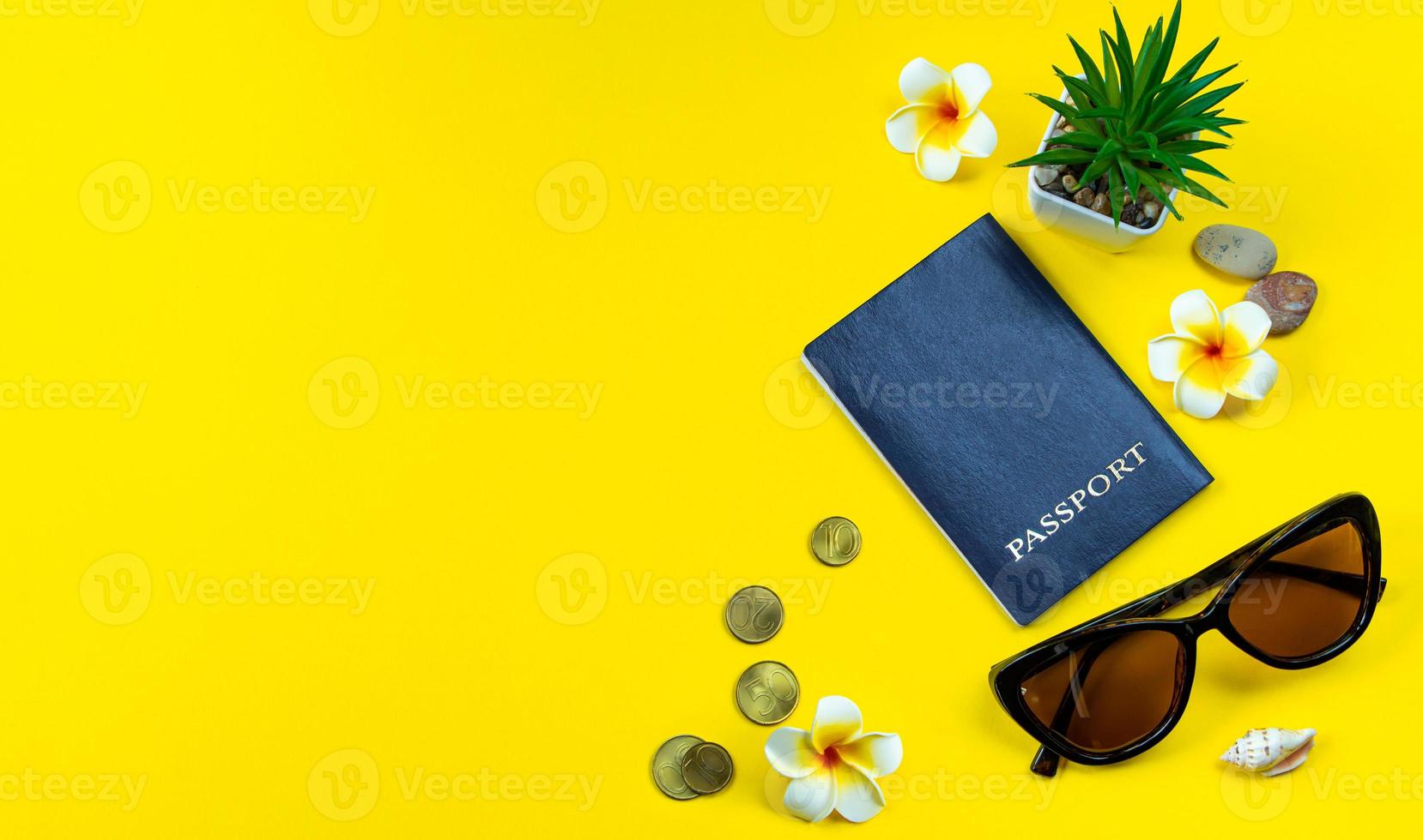 acessórios flatlay para as férias de verão. planejamento de viagens. passaporte, dinheiro, óculos de sol em um fundo amarelo. foto