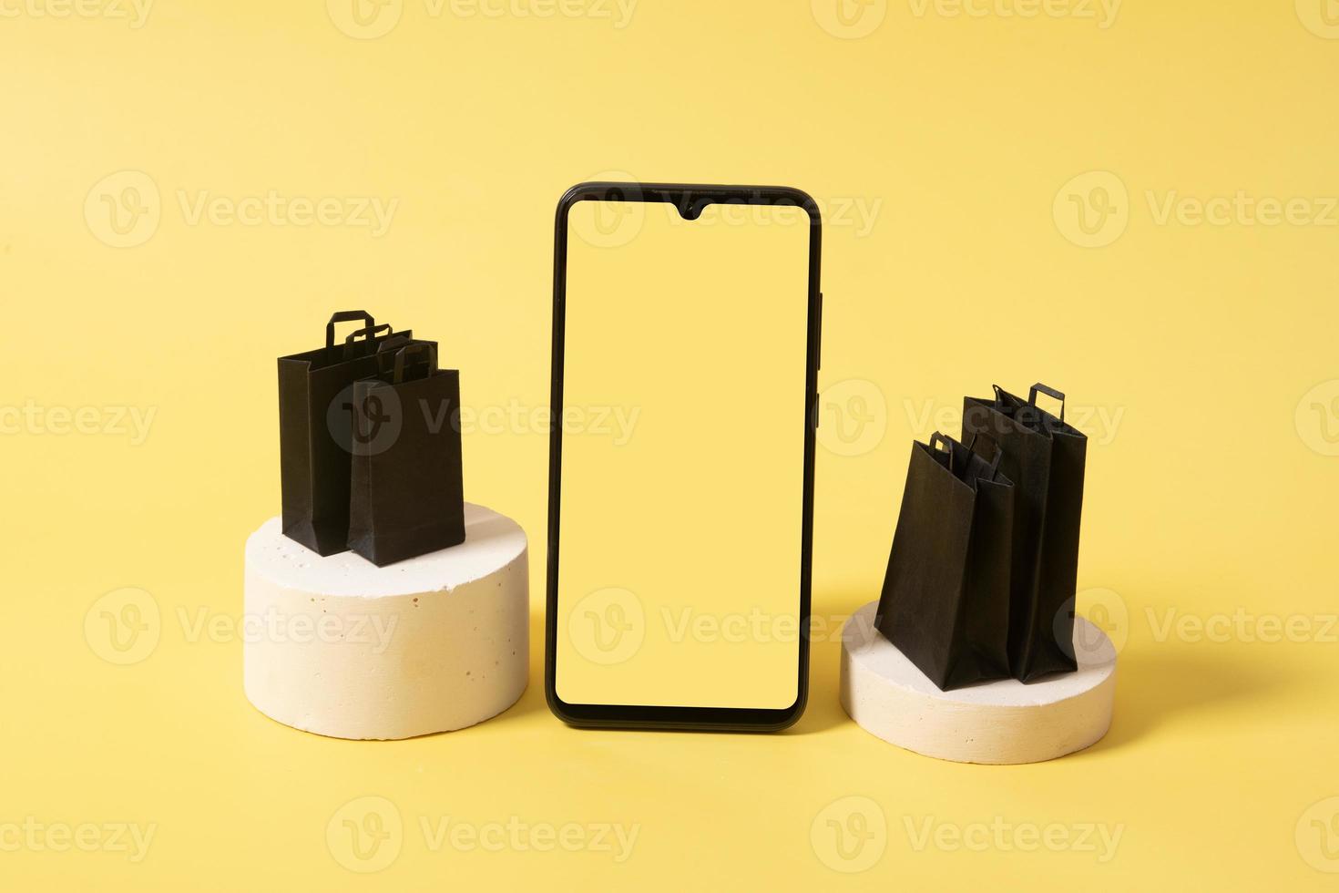 mock up de telefone e bolsas pretas no pódio com compras na liquidação de sexta-feira negra foto