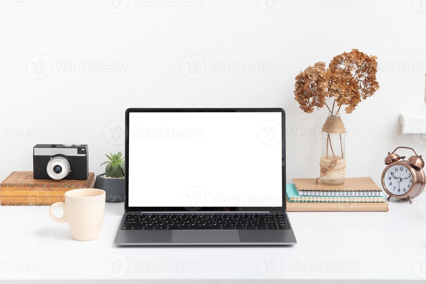 mesa de trabalho com tela de simulação de laptop em branco, câmera vintage e um copo de bebida. trabalho online, conceito freelance foto