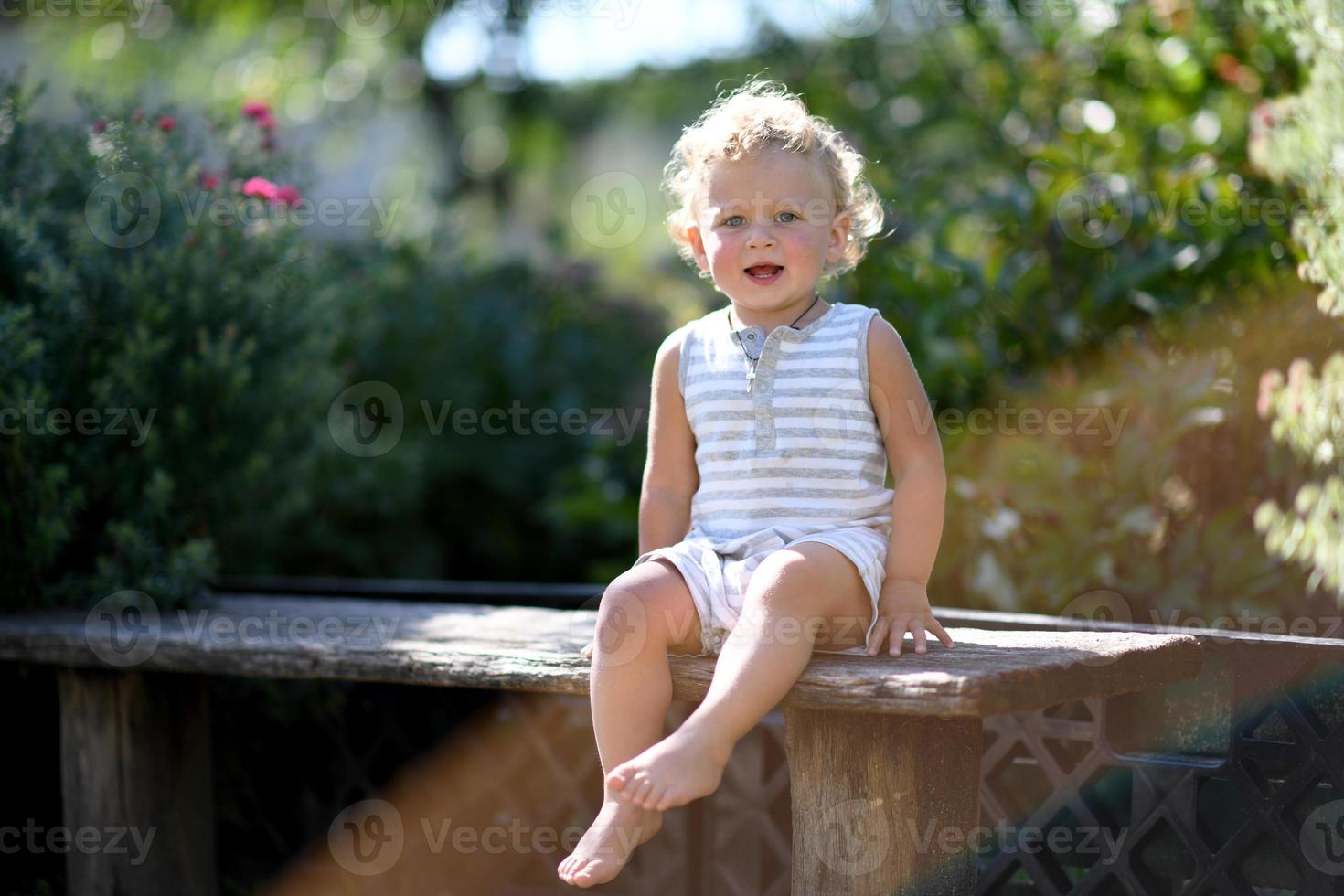 lindo menino no jardim infantil posando fotógrafo foto