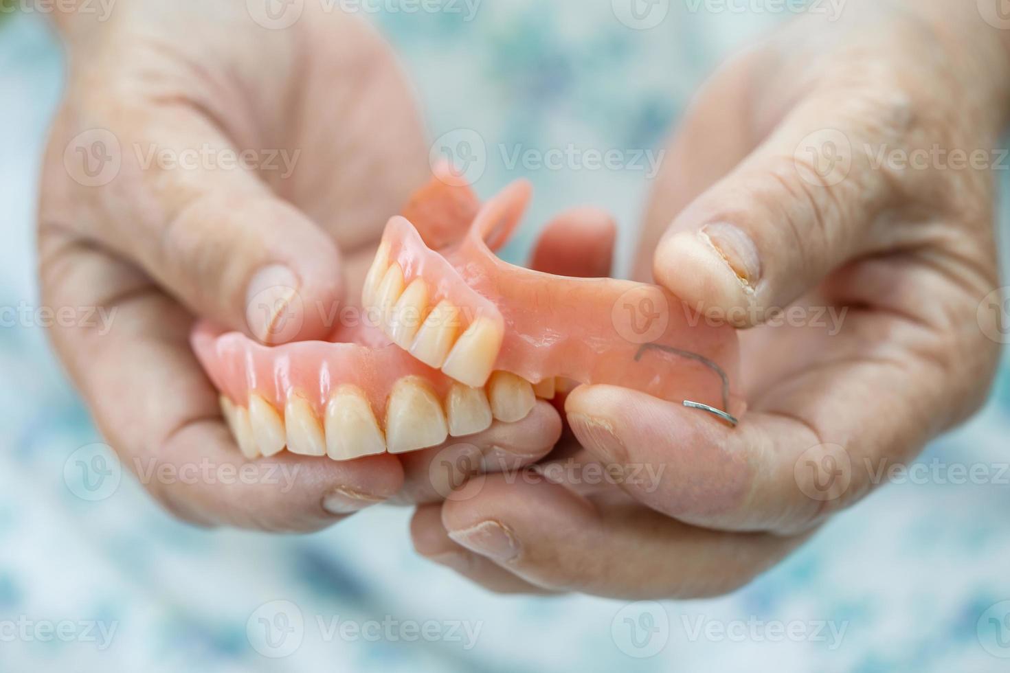 paciente asiático sênior ou idosa segurando para usar dentadura na enfermaria do hospital de enfermagem, conceito médico forte e saudável foto