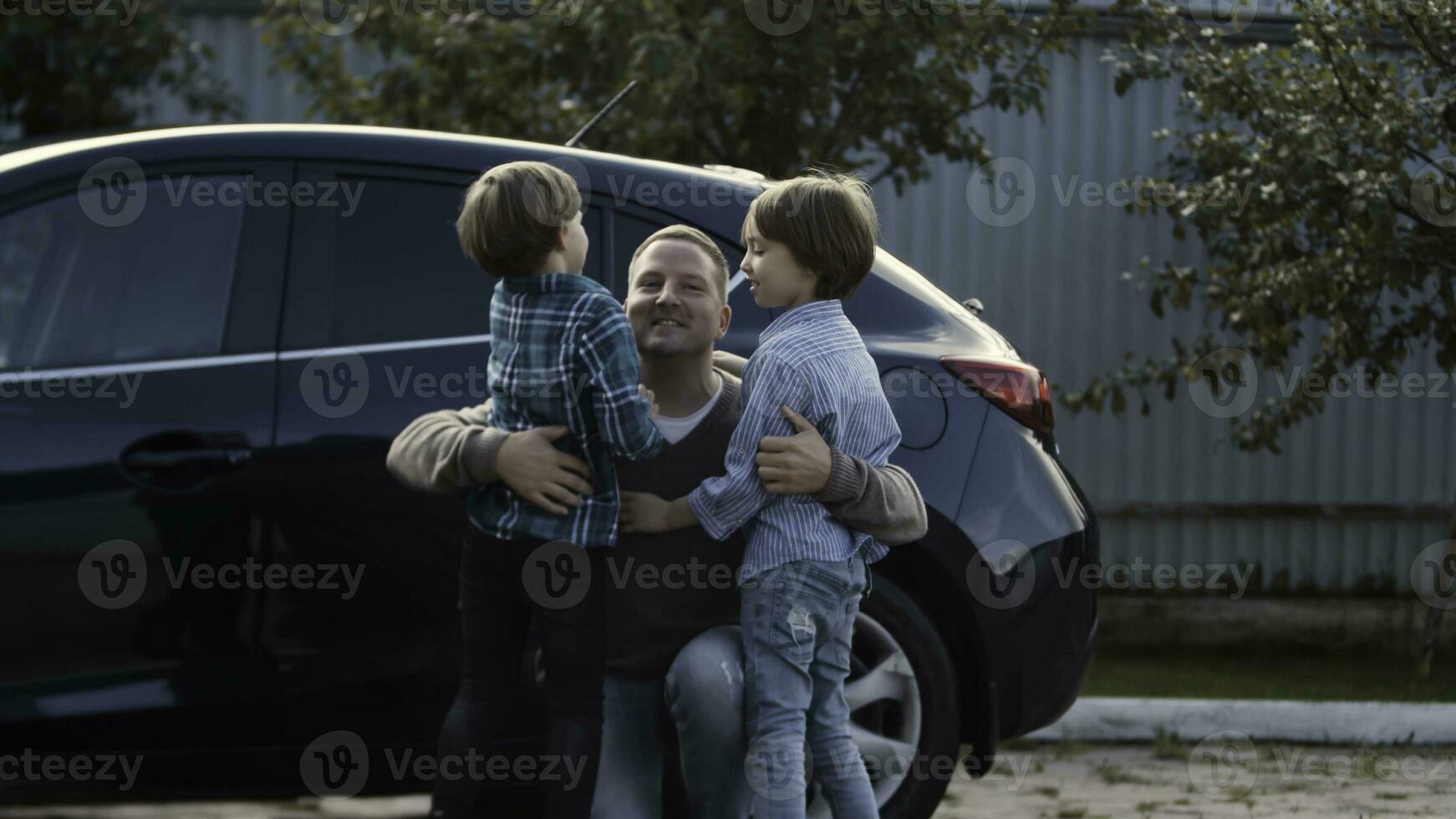 pai encontra dele pequeno Rapazes perto dele carro ao ar livre. estoque. conceito do feliz família e paternidade. foto