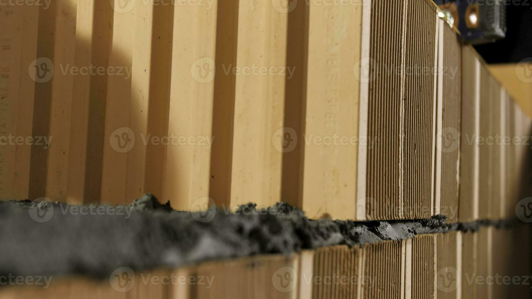 industrial trabalhador construção exterior paredes com laranja tijolos e argamassa. estoque imagens de vídeo. pedreiro colocando baixa outro linha do tijolos. foto