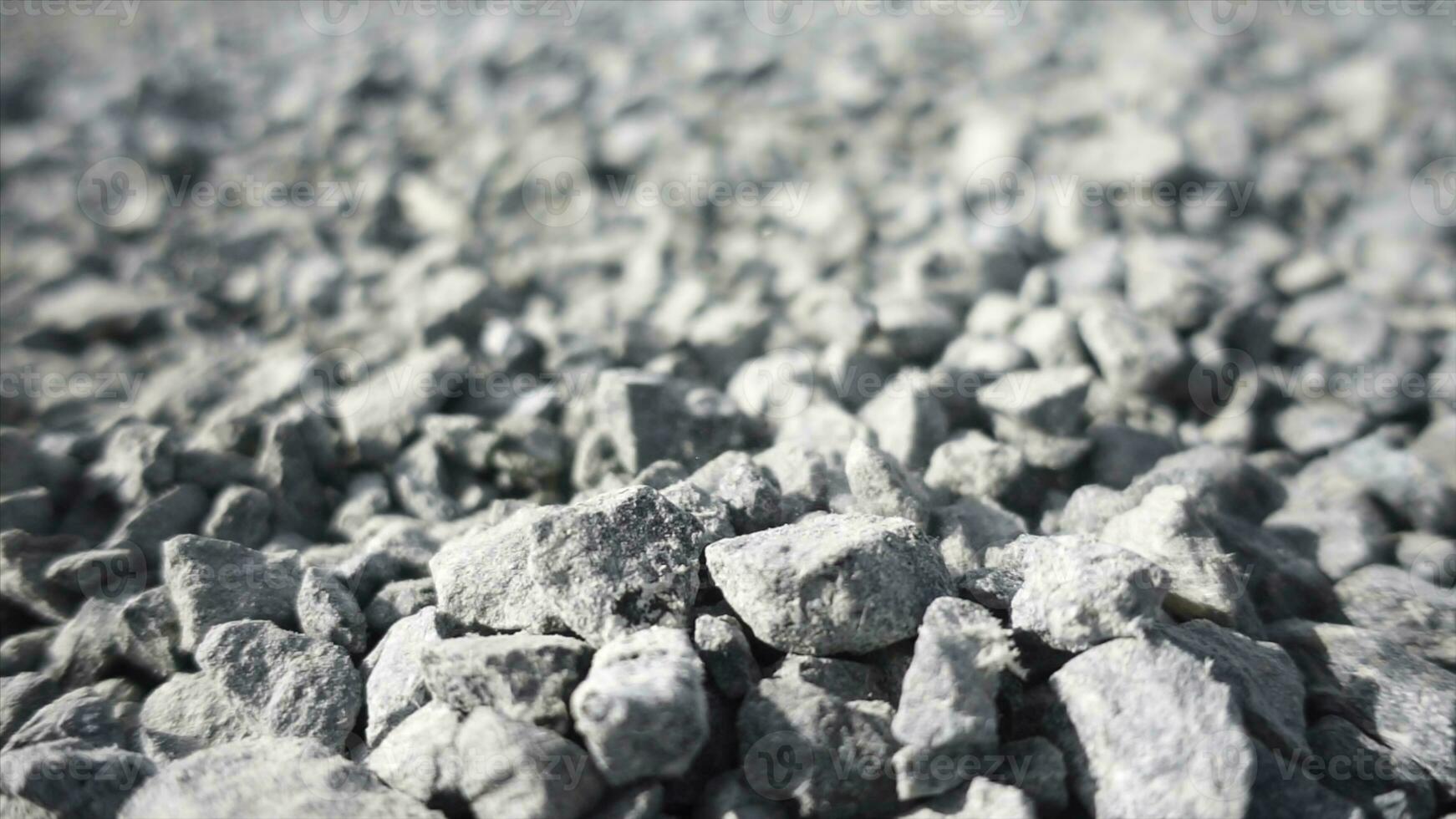 fundo do cinzento granito cascalho debaixo a brilhante Sol. estoque imagens de vídeo. fechar acima do branco pedras queda baixa em a chão, seixo textura. foto