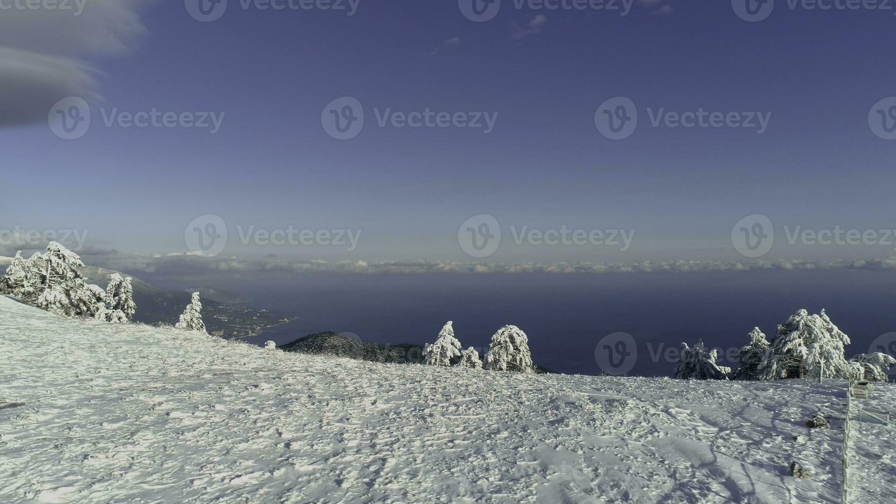 aéreo Visão do Nevado montanhas, mar, nublado céu. tomada. coberto de neve colinas de a mar foto