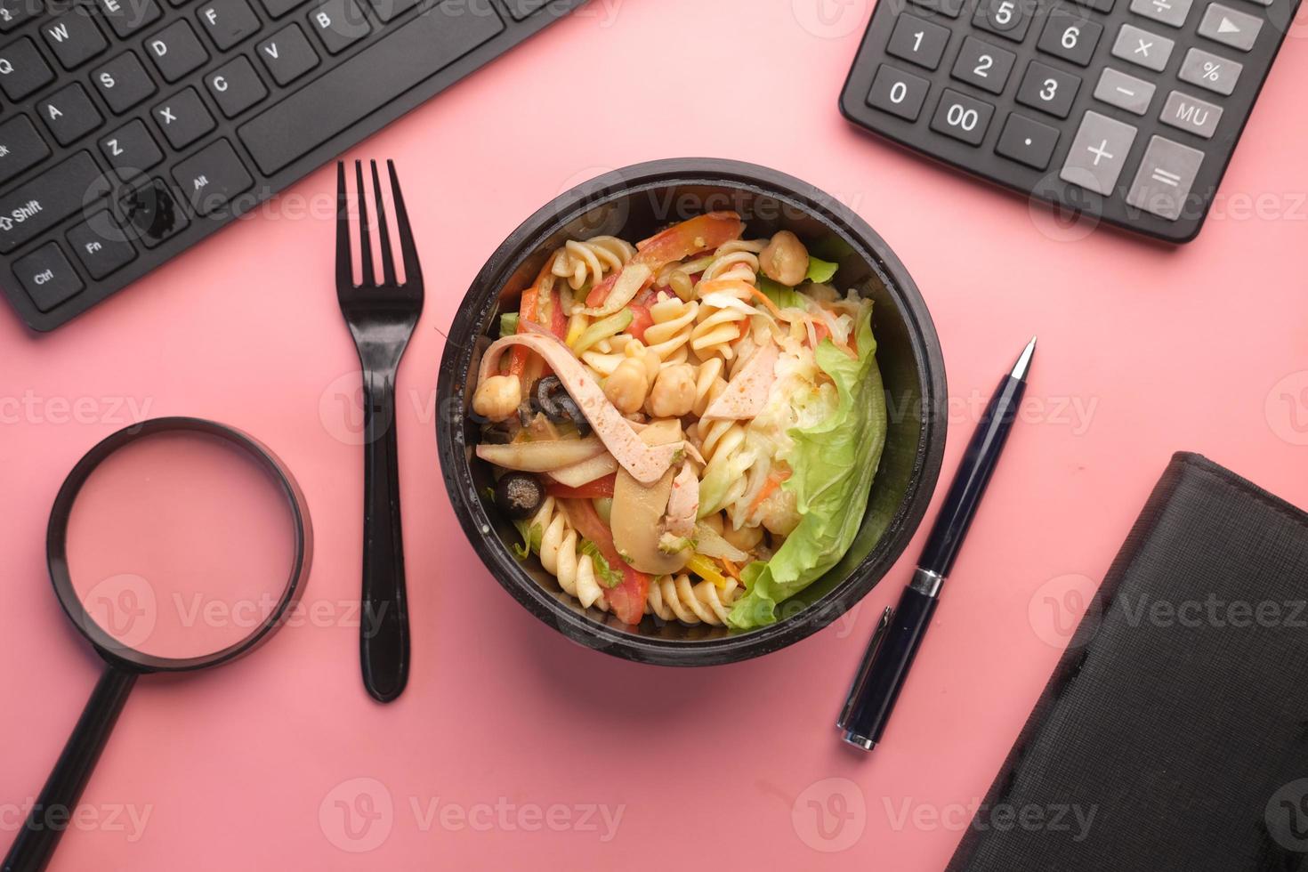 Salada de legumes fresca em uma tigela na mesa do escritório foto