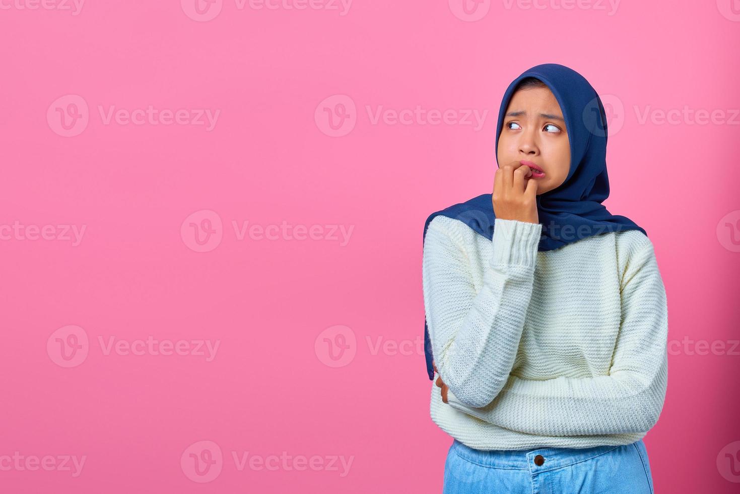 retrato de uma jovem asiática parecendo estressada e nervosa com a mão na boca roendo as unhas foto