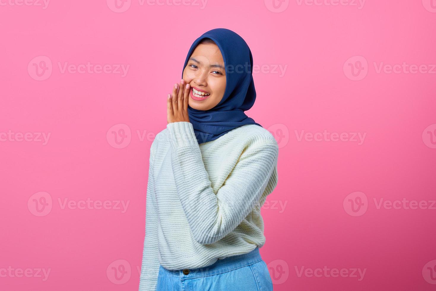 retrato de uma linda mulher asiática mantendo a mão perto da boca e sussurrando segredo foto