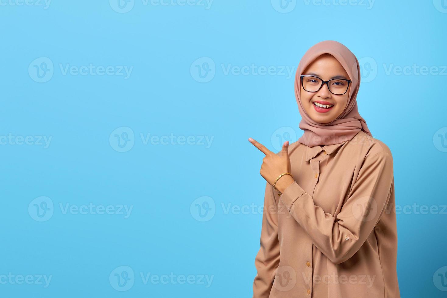 retrato de uma jovem asiática sorridente apontando para copiar o espaço com o dedo foto