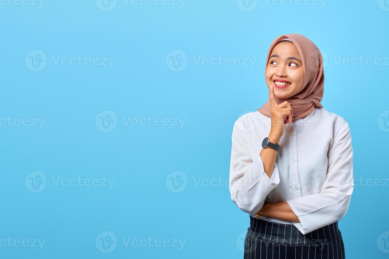 retrato de uma jovem asiática sorridente, pensando na pergunta com o dedo no queixo foto