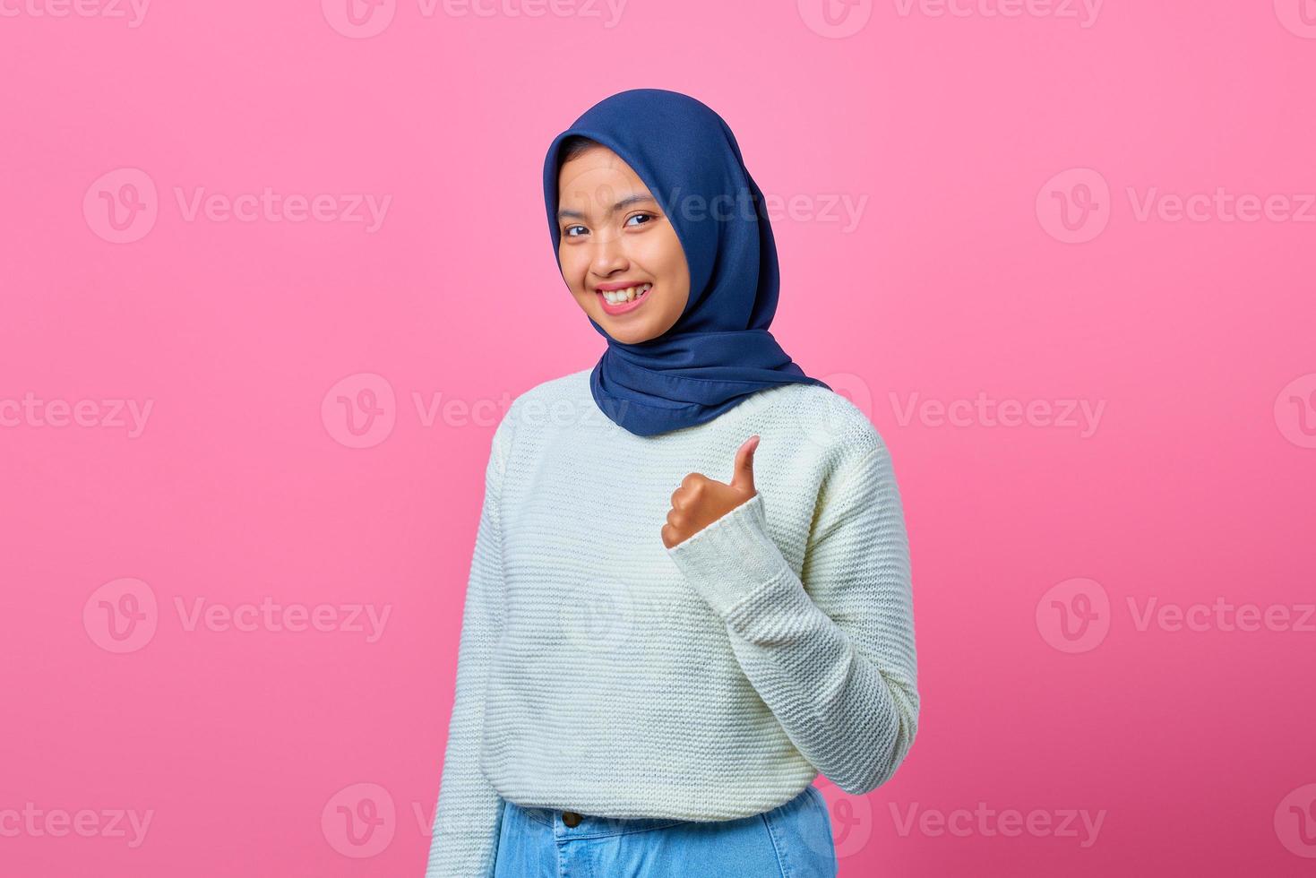 retrato de uma linda mulher asiática sorridente, mostrando os polegares para cima ou um sinal de aprovação foto