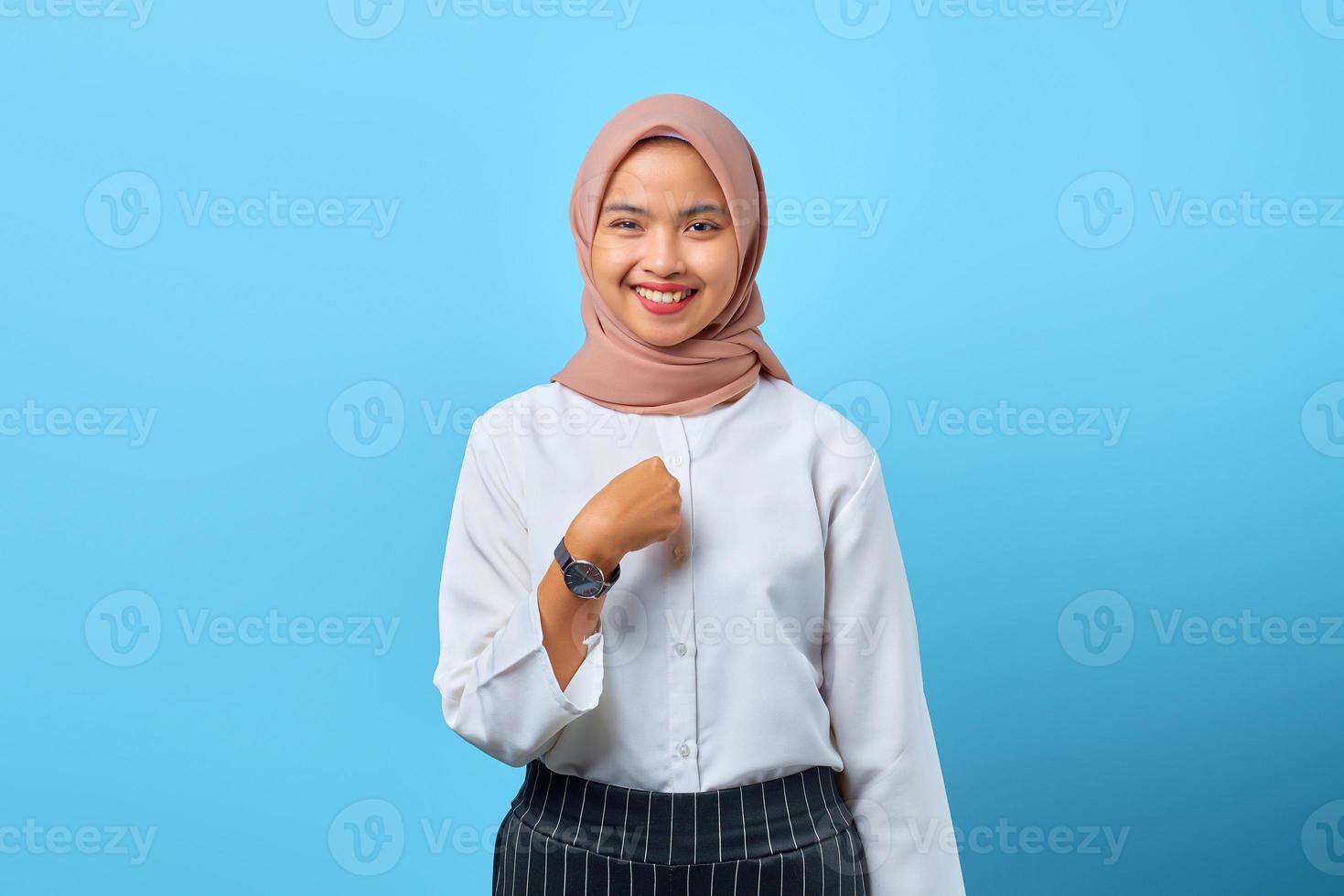 retrato de uma jovem asiática sorridente apontando os dedos para si mesma sobre um fundo azul foto