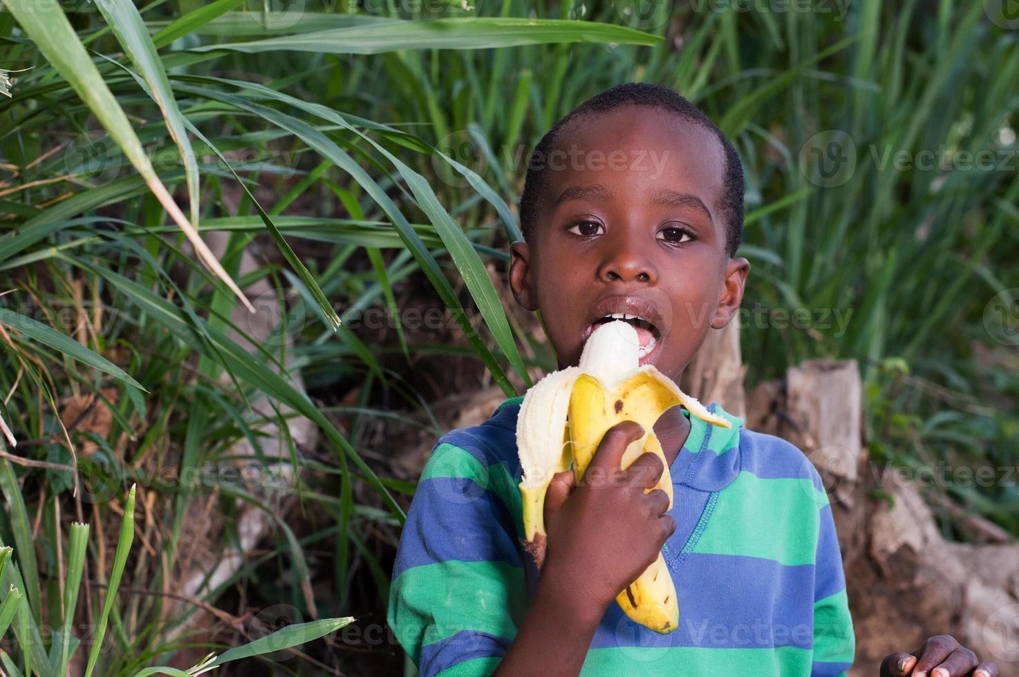 menino comendo uma fruta. foto