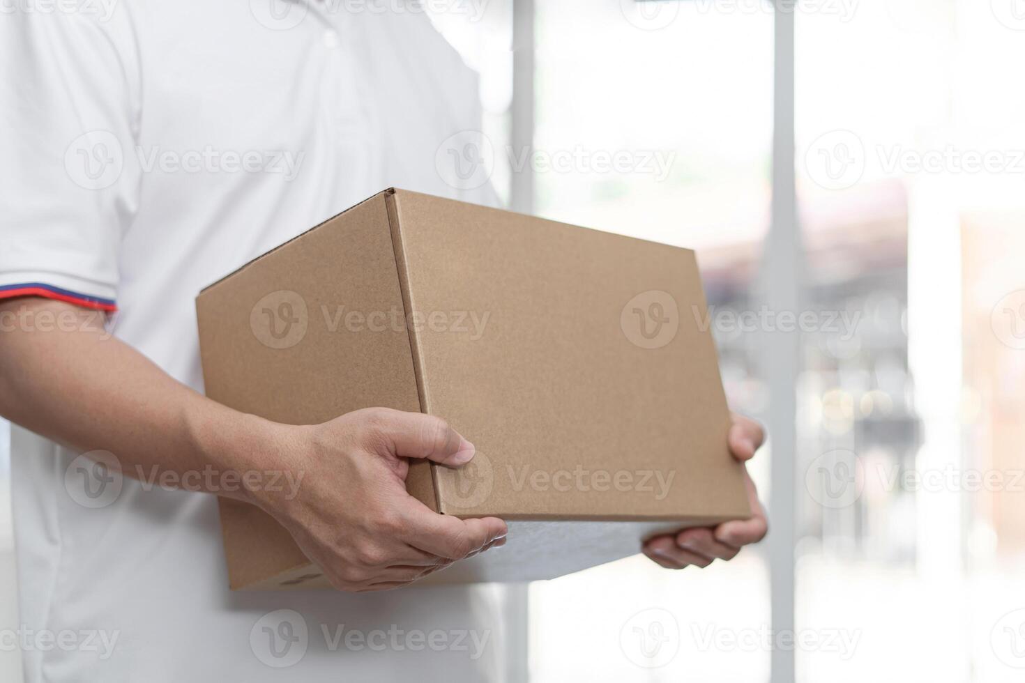 Entrega homem vestem uma branco camisa aguarde cartão caixa dentro casa fundo serviço quarentena pandemia coronavírus vírus 2019-ncov conceito foto