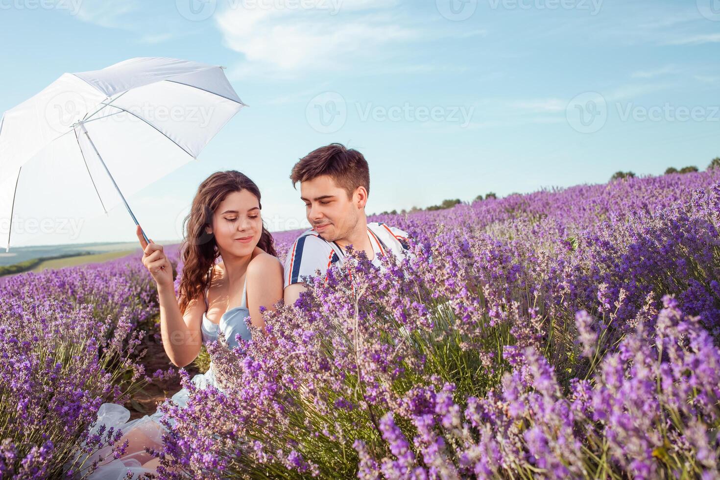 uma casal dentro amor debaixo uma branco guarda-chuva em uma lavanda campo amor foto