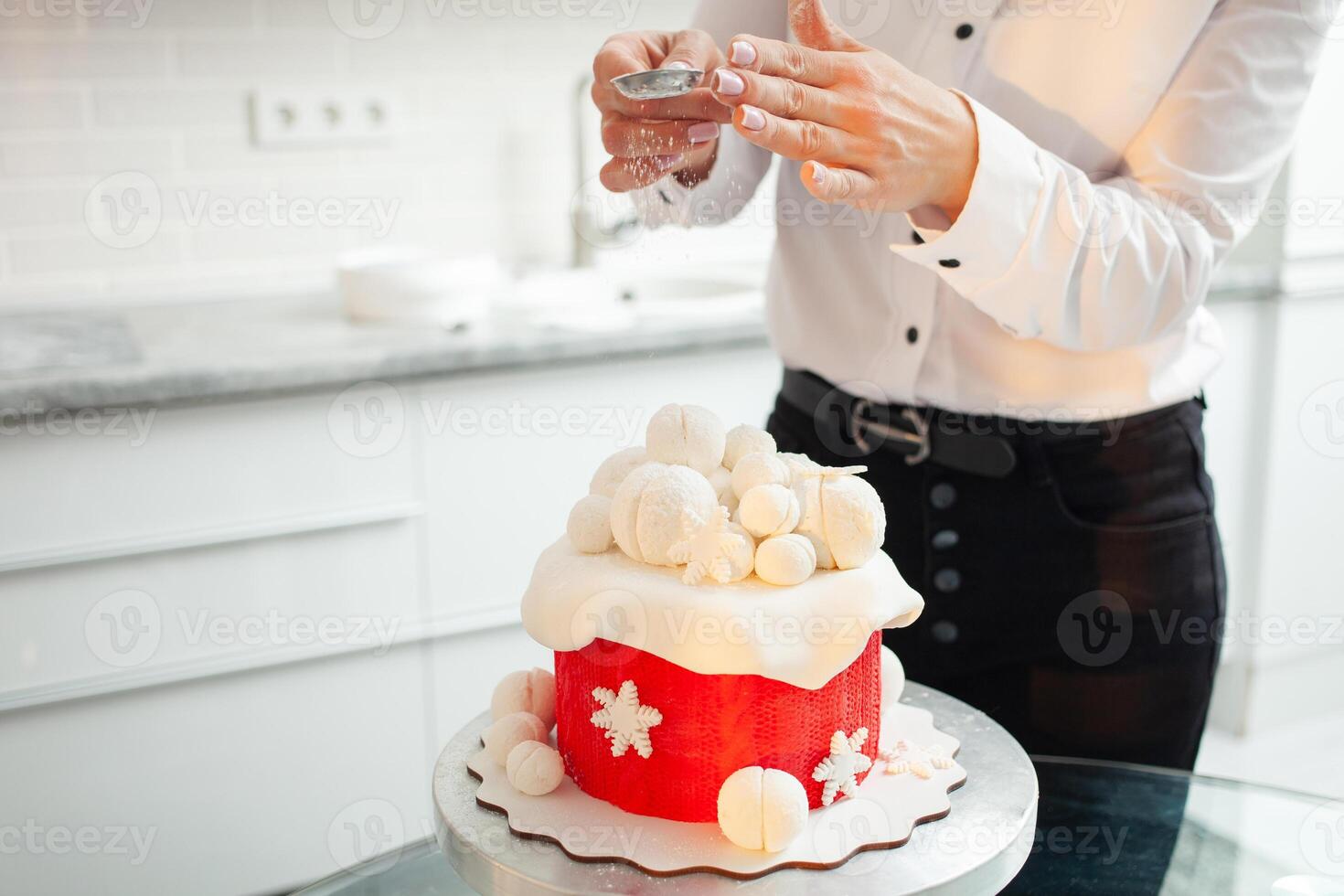 pastelaria chefe de cozinha decora bolo com pó, neve. lindo bolo para Natal, Novo ano, feriado. casa Produção, o negócio mulher, empreendedor, passatempo. foto