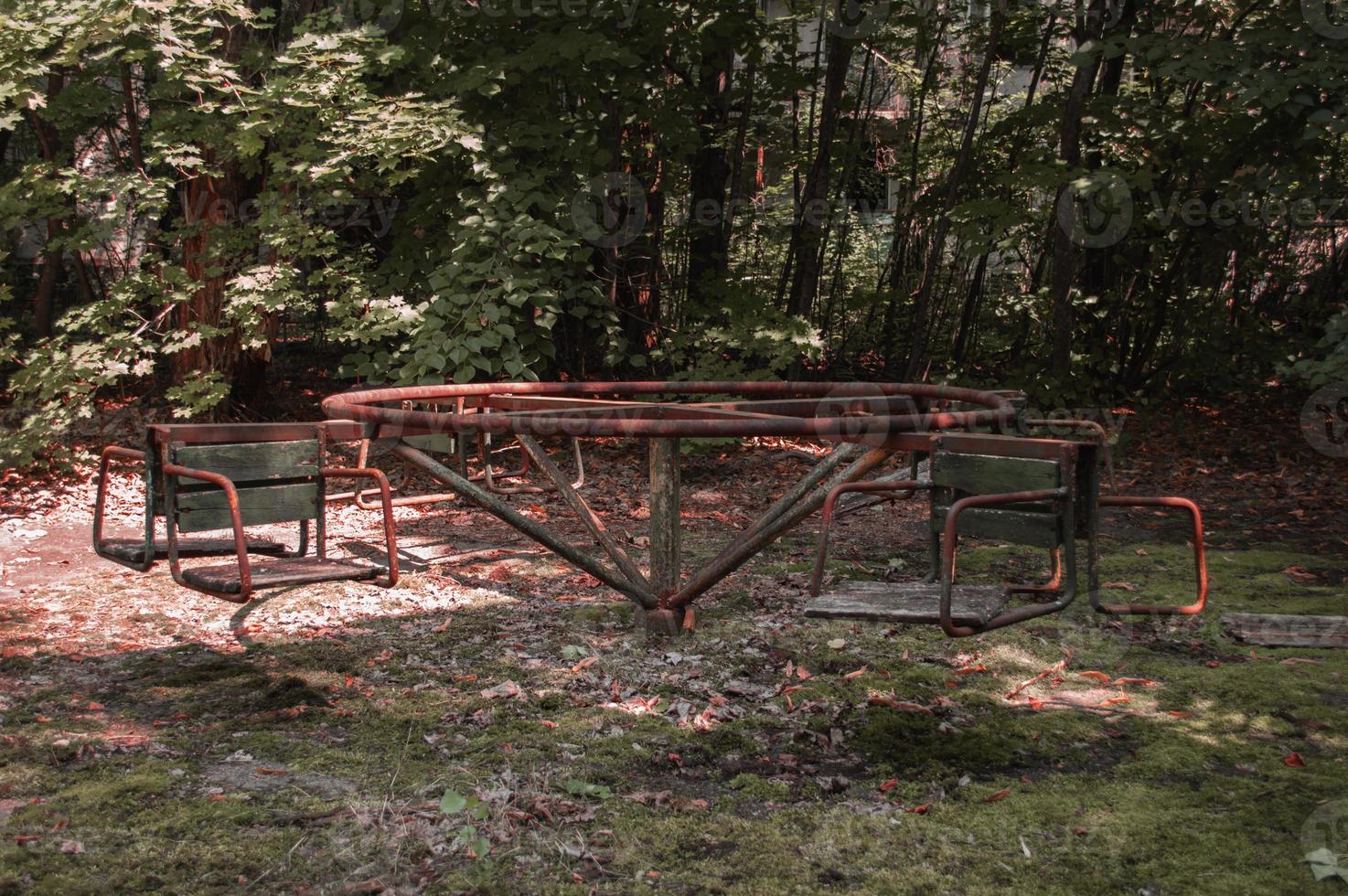 um playground abandonado radioativo coberto de árvores na cidade de Pripyat foto