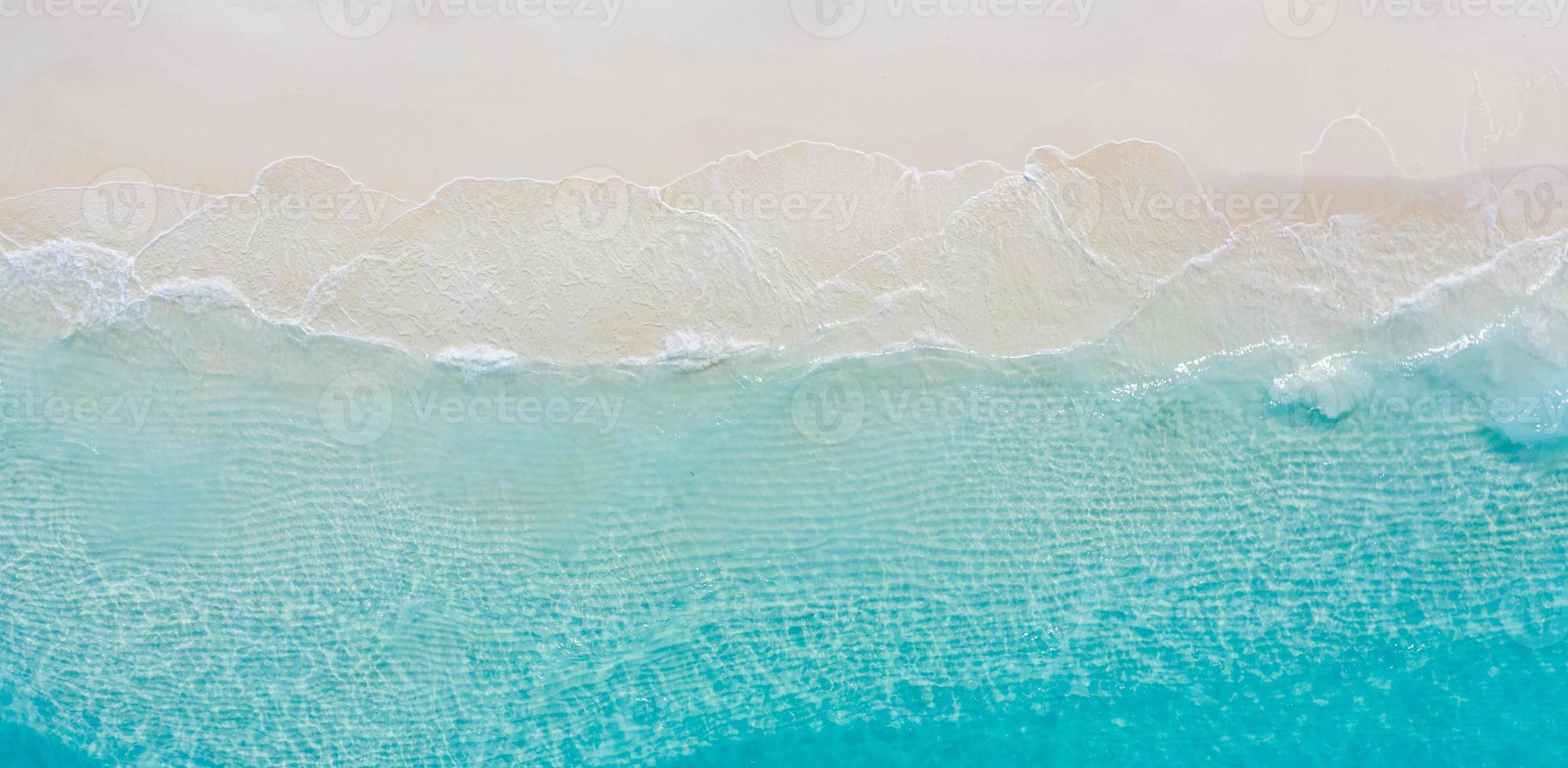 verão seascape belas ondas, água do mar azul em um dia ensolarado. vista superior do drone. vista aérea do mar, incrível fundo de natureza tropical. belo mar brilhante com ondas espirrando e conceito de areia de praia foto