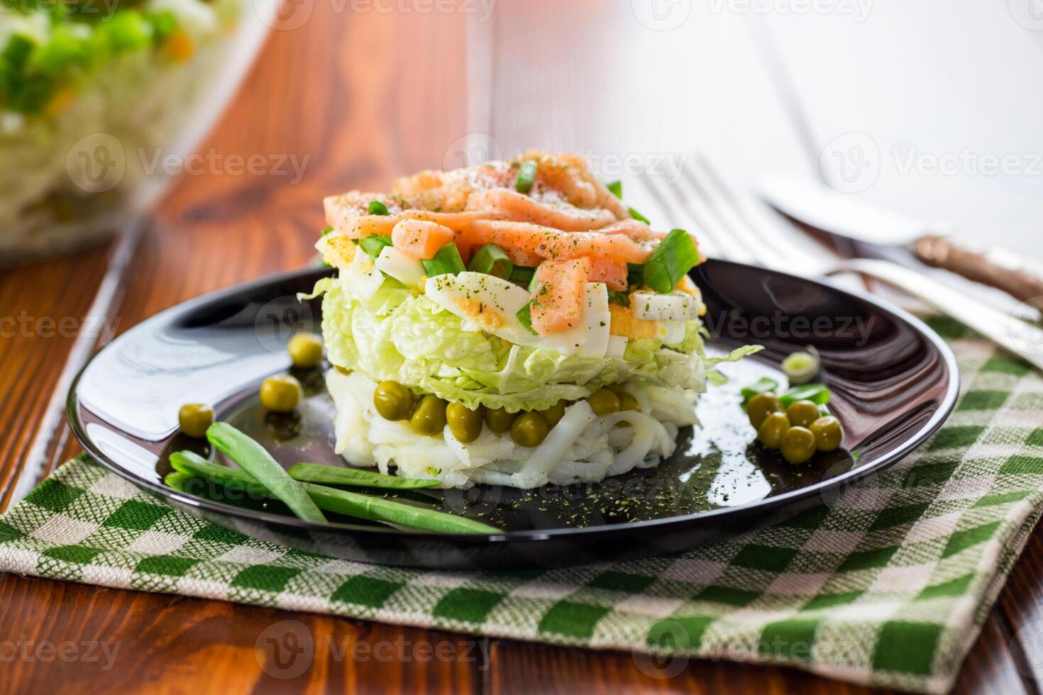 em camadas salada do repolho e de outros legumes com peças do vermelho peixe dentro uma placa. foto