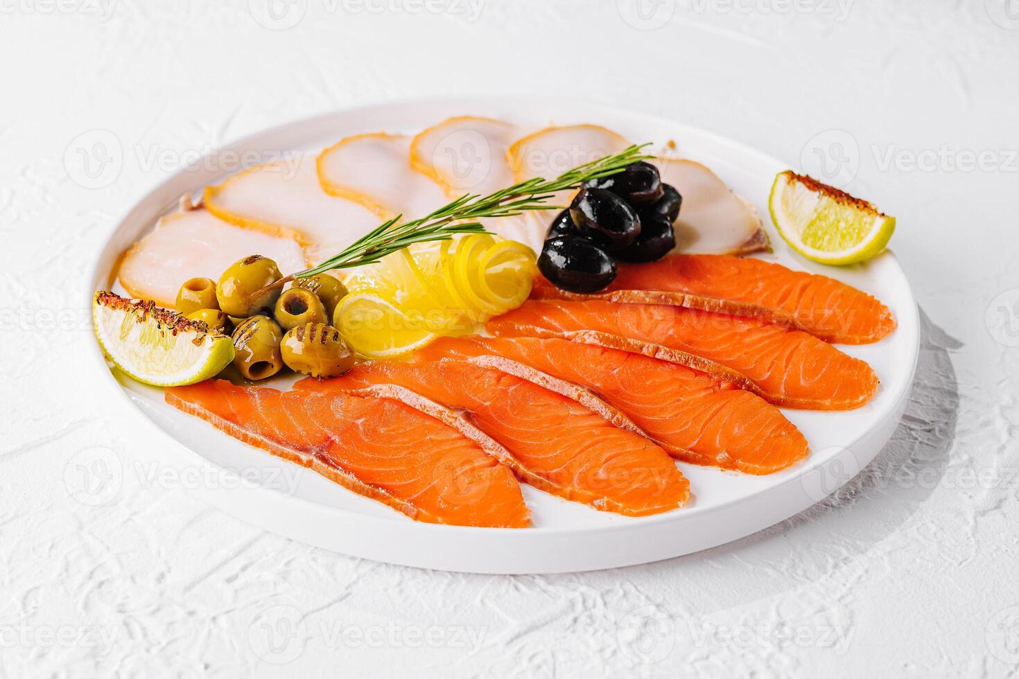 salmão, branco peixe e azeitonas em prato foto
