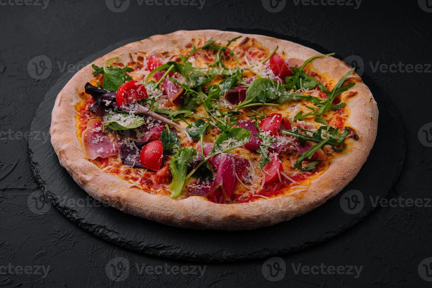 italiano pizza com prosciutto, Rúcula e cereja tomates foto