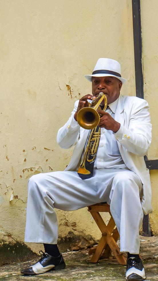 havana, cuba, 4 de julho de 2017 - homem não identificado tocando trompete na rua de havana, cuba. músicos de rua são comuns em havana, onde tocam música para turistas. foto
