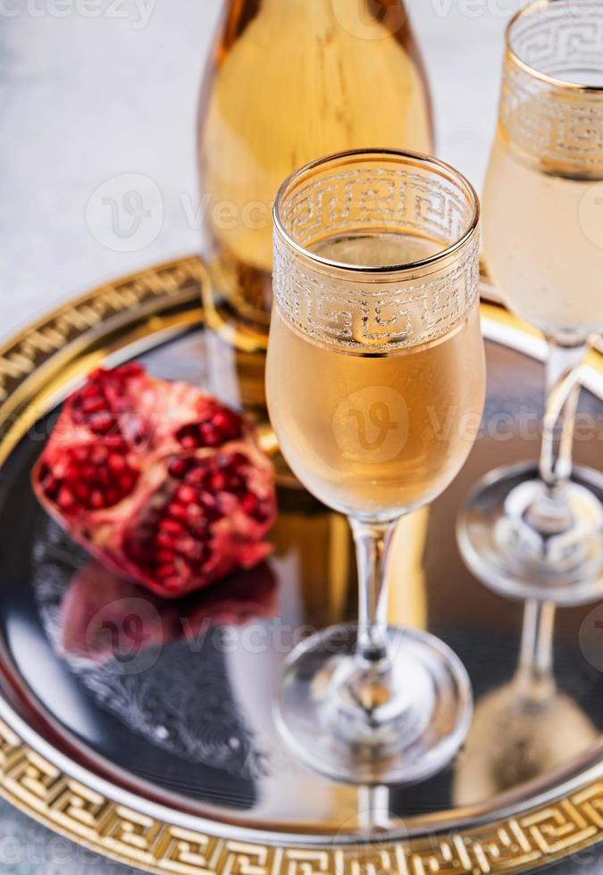 taças e garrafa com champanhe em uma bandeja foto