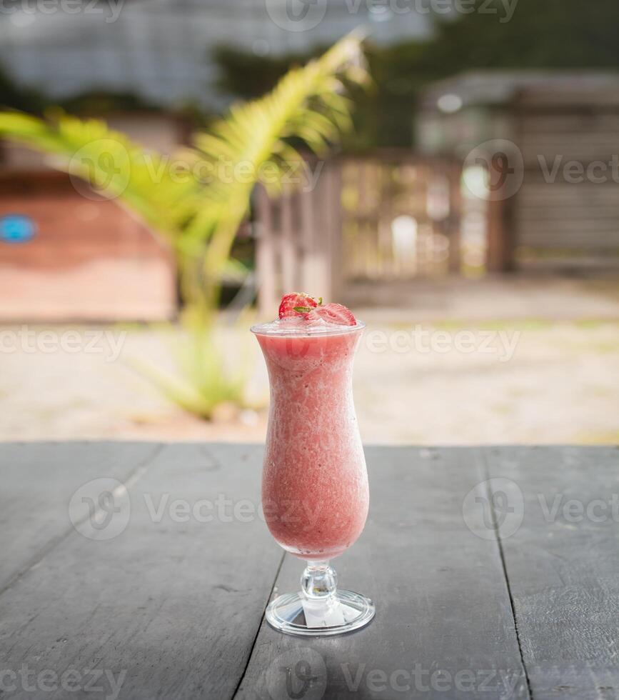 fechar acima do saudável morango batido em madeira com borrado fundo, morango batido em de madeira mesa. morango milkshake em de madeira mesa com borrado fundo foto