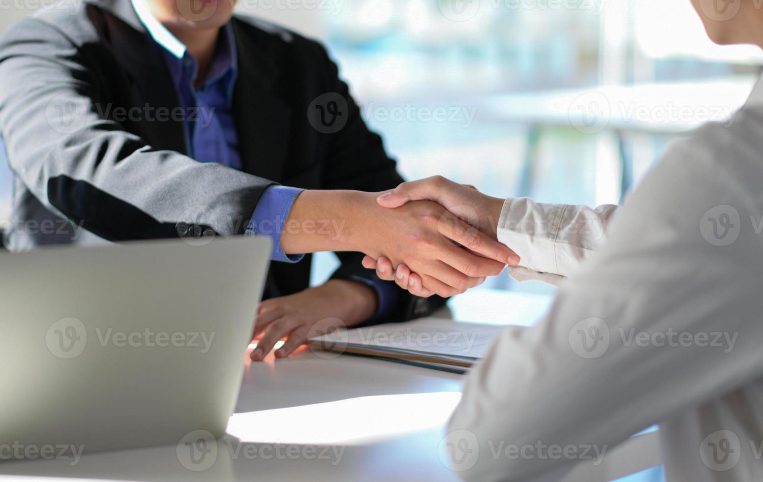 foto recortada de executivos dando as mãos para parabenizar o novo funcionário por meio da entrevista.