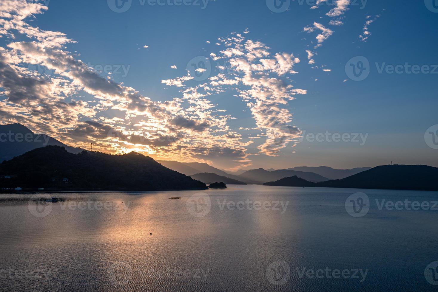 o lago noturno refletia o brilho do pôr do sol e as montanhas foto