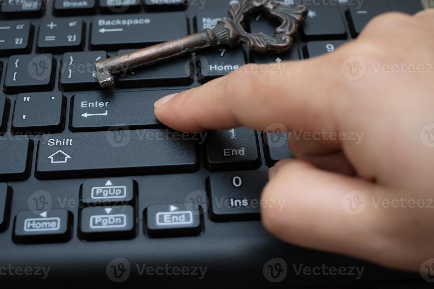 fechar o botão de pressão do dedo indicador feminino entrar no teclado do computador foto