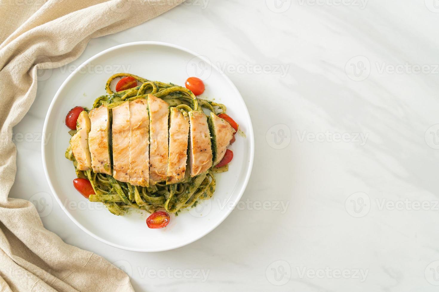 macarrão fettuccine espaguete ao molho pesto com frango grelhado foto