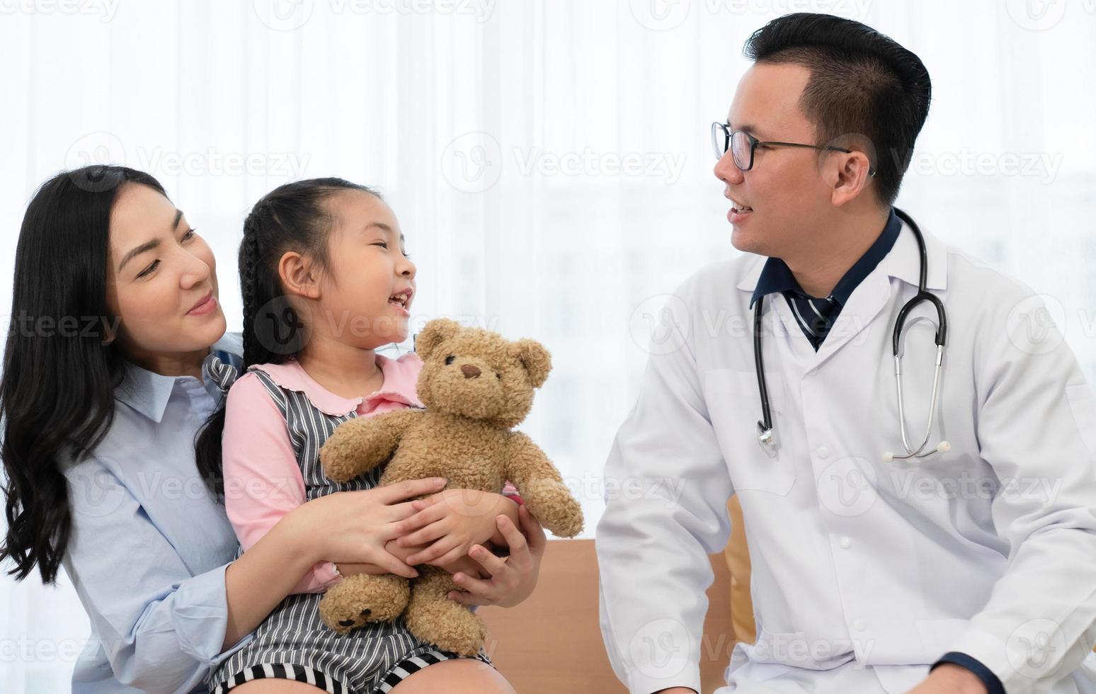 médico asiático falando com a jovem e a mãe que visitam a clínica pediátrica no hospital. carro de saúde e conceito médico foto